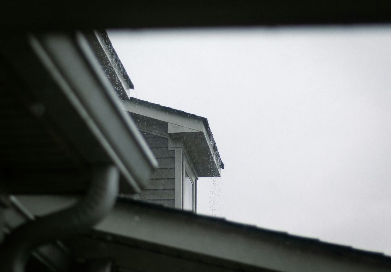 Dark seamless gutters along a modern suburban roofline